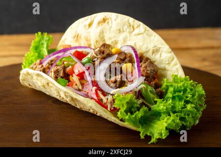 Tacos messicani con manzo, cipolle, peperoni caldi, mais, pomodori e formaggio. Autentici tacos, birria, carne asada, adobada, cabeza, e chicharroni. Casa Foto Stock