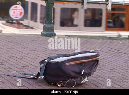 Zaino sul lato della strada; borsa abbandonata sulla strada allarme bomba; sicurezza della città, Amsterdam, Paesi Bassi. Foto Stock