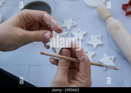 La star del Natale Creator sta usando l'argilla secca bianca per creare decorazioni per le vacanze sull'albero di Natale. Creazione di attività ricreative hobby che coinvolgono le dita. Fai da te per creare arte moderna Foto Stock