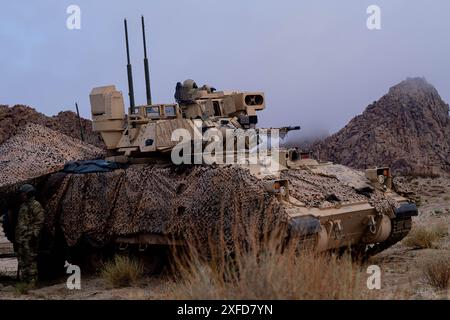 M2A3 Bradley Fighting Vehicle assegnato alla 1st Armored Brigade Headquarters Company, 1st Armored Brigade Combat Team, 1st Armored Division, tira la sicurezza al National Training Center, Fort Irwin, California, 6 febbraio 2024. (Foto U.S. Army di SPC. David Poleski) Foto Stock