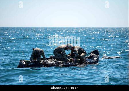 Gli operatori della Naval Special Warfare (NSW) della West Coast assemblano un mezzo da combattimento in gomma vicino al sottomarino ad attacco rapido classe Los Angeles USS Greeneville (SSN 772) durante l'addestramento all'interoperabilità della flotta nell'Oceano Pacifico orientale. Il NSW è la forza militare militare militare marittima d'élite della nazione, posizionata in modo unico per estendere la portata della flotta e ottenere e mantenere l'accesso per la Joint Force in competizione e conflitto. Foto Stock