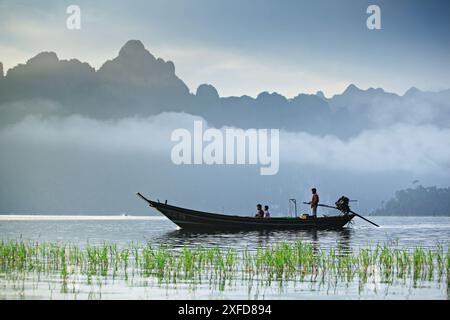 Surat Thani, Thailandia - 23 ottobre 2012: Le tradizionali barche a coda lunga portano i turisti a vedere la bellezza della diga di Ratchaprapha Foto Stock