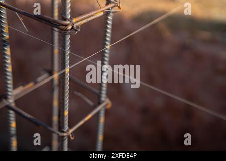 Armature per fondazioni in calcestruzzo in un cantiere. Barre in acciaio e struttura in ferro pronte per la fusione di calcestruzzo. Materiali e tecniche essenziali Foto Stock