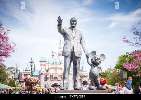 Anaheim, California USA - 6 aprile 2017: Statua dei partner, Walt Disney e Topolino, circondati da fiori primaverili con sfondo al castello di Disneylan Foto Stock