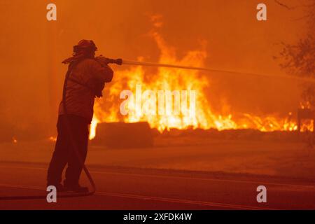 Oroville, Stati Uniti. 10 maggio 2024. I vigili del fuoco abbattono i punti caldi mentre l'incendio Thompson si prepara a saltare Canyon Rd a Oroville, California, martedì 2 luglio 2024. Il caldo estremo ha colpito i paesaggi asciutti costringendo le evacuazioni mentre la California entra nella stagione degli incendi. Foto di Peter DaSilva/UPI credito: UPI/Alamy Live News Foto Stock