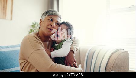 Casa, nonna e abbraccio per piangere il bambino, triste e confortevole in soggiorno, abbraccio e amore. Appartamento, nonna e donna anziana con neonato, bambino e. Foto Stock