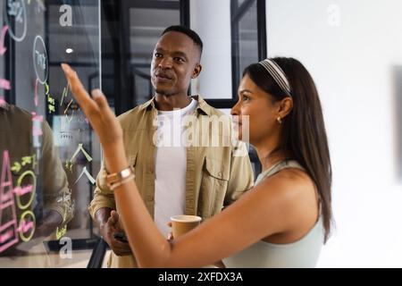 Brainstorming di idee sulla lavagna di vetro, colleghi che discutono della strategia aziendale in ufficio Foto Stock