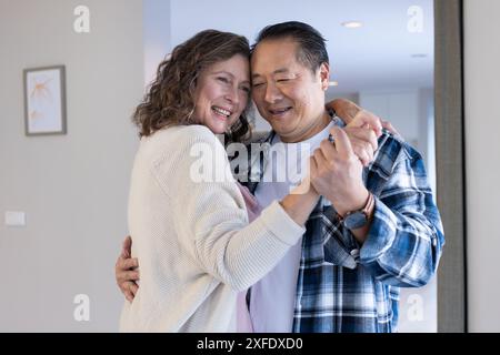 Ballare insieme, sorridere coppia anziana in un ambiente accogliente Foto Stock