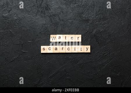 Parola di scarsità di acqua scritta su blocco di legno. Testo di scarsità di acqua sul tavolo di cemento per il vostro desing, concetto. Foto Stock