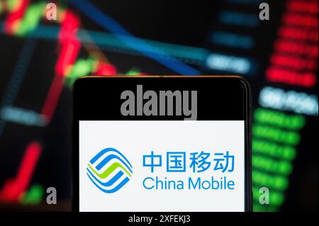 Cina. 21 giugno 2024. In questa illustrazione fotografica, il logo China Mobile, società di telecomunicazioni statale cinese, è stato visualizzato su uno smartphone con un grafico dell'indice di borsa economica sullo sfondo. Credito: SOPA Images Limited/Alamy Live News Foto Stock