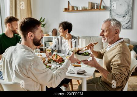 Una coppia gay si diverte a mangiare con la propria famiglia a casa. Foto Stock