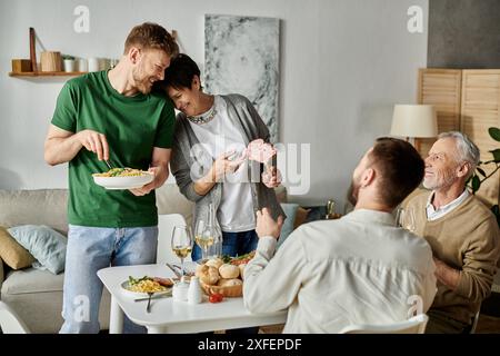 Una coppia gay si gode una cena con i genitori a casa. Foto Stock