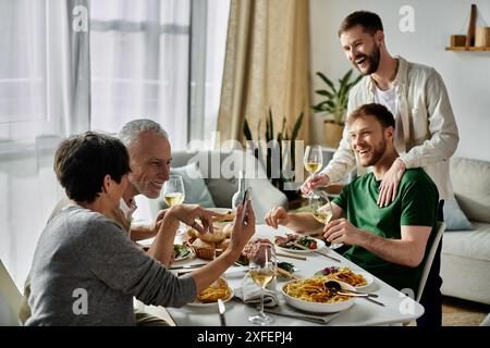 Una coppia gay si diverte a cenare con la famiglia a casa, condividendo risate e buon cibo. Foto Stock