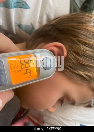 Paesi Bassi, il termometro per orecchie viene utilizzato per misurare la temperatura di un bambino malato. Foto Stock