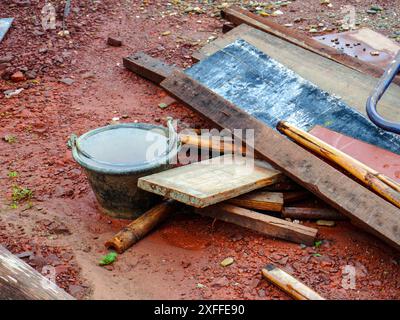 Mucchi di legname da costruzione rimasto sono stati lasciati insieme a vari strumenti per lavorare in un cantiere rurale. Foto Stock