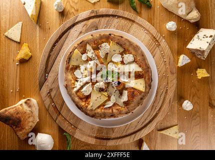 Pizza artigianale gourmet con quattro formaggi su un tavolo di legno Foto Stock