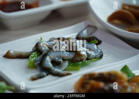 Il pesce crudo di cetriolo di mare, chiamato ginseng selvatico del mare, è apprezzato nei paesi asiatici, tra cui la Corea Foto Stock