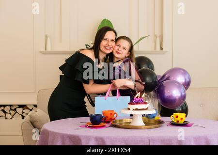 Madre e figlia si abbracciano durante la festa di compleanno. Famiglia felice Foto Stock