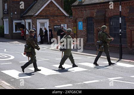 Fine settimana della seconda Guerra Mondiale nella Gola di Ironbridge. Non fatevi prendere dal panico sono solo i reenattori vestiti da invasori tedeschi nazisti che attraversano la strada in sicurezza su un britannico Foto Stock