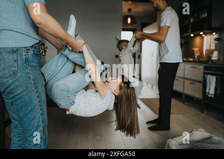 Ragazza giocosa che passa il tempo libero con la madre nel soggiorno di casa Foto Stock