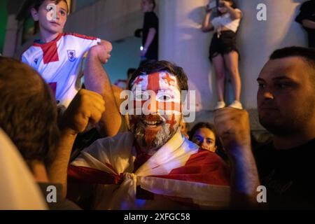 Tbilisi, Georgia. 3 luglio 2024. Un uomo con la bandiera georgiana dipinta sul viso alza i pugni per festeggiare la nazionale di calcio. La squadra di calcio georgiana ha visitato Tbilisi per celebrare un posto storico nella UEFA Champions League dopo aver vinto contro il Portogallo nella fase a gironi ma aver perso contro la Spagna nelle qualificazioni. Credito: SOPA Images Limited/Alamy Live News Foto Stock