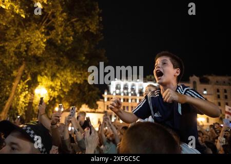 Tbilisi, Georgia. 3 luglio 2024. Un giovane tifoso fa il tifo mentre l'autobus che porta la squadra nazionale di calcio georgiana passa davanti. La squadra di calcio georgiana ha visitato Tbilisi per celebrare un posto storico nella UEFA Champions League dopo aver vinto contro il Portogallo nella fase a gironi ma aver perso contro la Spagna nelle qualificazioni. Credito: SOPA Images Limited/Alamy Live News Foto Stock