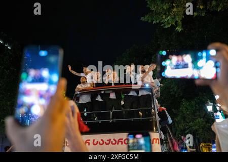 Tbilisi, Georgia. 3 luglio 2024. I tifosi scattano foto della squadra nazionale di calcio georgiana mentre si avvicinano a Piazza della libertà a bordo di un autobus scoperto. La squadra di calcio georgiana ha visitato Tbilisi per celebrare un posto storico nella UEFA Champions League dopo aver vinto contro il Portogallo nella fase a gironi ma aver perso contro la Spagna nelle qualificazioni. Credito: SOPA Images Limited/Alamy Live News Foto Stock