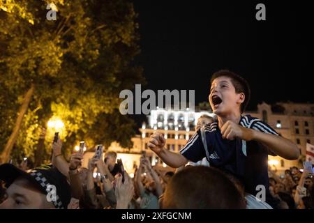 Tbilisi, Georgia. 3 luglio 2024. Un giovane tifoso fa il tifo mentre l'autobus che porta la squadra nazionale di calcio georgiana passa davanti. La squadra di calcio georgiana ha visitato Tbilisi per celebrare un posto storico nella UEFA Champions League dopo aver vinto contro il Portogallo nella fase a gironi ma aver perso contro la Spagna nelle qualificazioni. (Foto di Jay Kogler/SOPA Images/Sipa USA) credito: SIPA USA/Alamy Live News Foto Stock