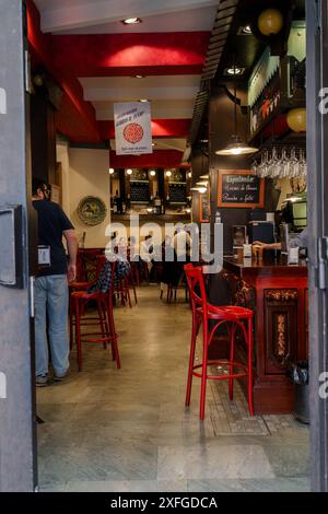 Siviglia, Spagna. 5 febbraio 2024 - sgabelli da bar rossi e clienti in un ristorante tradizionale spagnolo Foto Stock