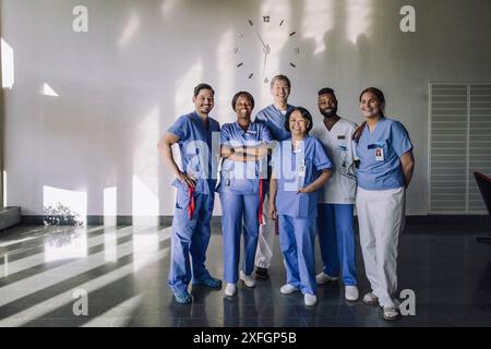 Ritratto di uomini felici e donne esperti medici in piedi insieme davanti all'ospedale Foto Stock