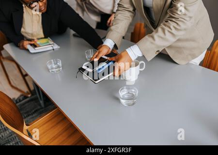 Vista dall'alto dell'imprenditrice che prende il diario e lo smartphone nella sala riunioni Foto Stock