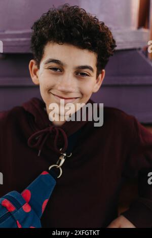 Ritratto di un ragazzo sorridente con capelli ricci Foto Stock