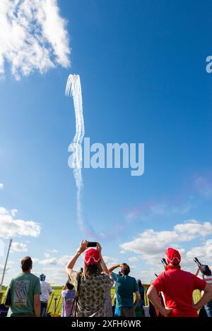 Il team di Royal Air Force Red Arrows si sta abbassando da un loop alto con gli appassionati che guardano e fotografano. Appassionati di merchandising Red Arrows Foto Stock