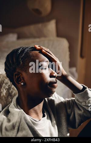 Adolescente depresso seduto in camera da letto a casa Foto Stock