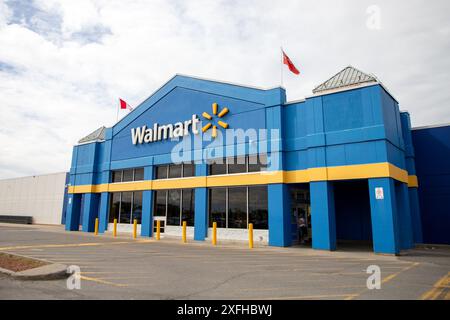 Kanata, Canada - 2 giugno 2024: Edificio di negozi Walmart con bandiere canadesi e dell'Ontario Foto Stock