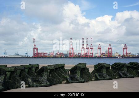 Acqua bassa espone le difese del mare, mostrando un calcestruzzo pre-formata groyne installato per calmare le acque all'estuario del fiume Mersey, New Brighton, Wallasey, Wirral, Merseyside, Regno Unito Foto Stock