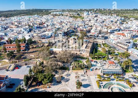 Vista aerea di Ayia Napa, Cipro, che mostra il contrasto tra l'antico monastero e gli edifici moderni in una giornata di sole Foto Stock