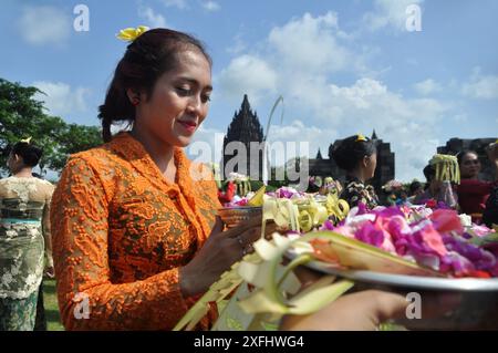 Giava centrale, Indonesia - 1 marzo 2015 : la giovane donna indù tiene in mano un vassoio contenente fiori e offerte mentre prega al Tempio di Prambanan, J centrale Foto Stock