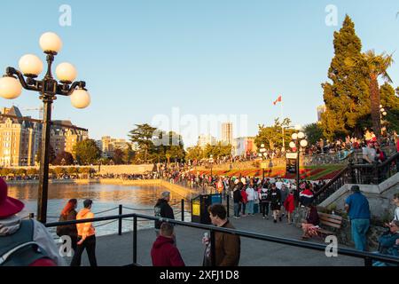 Victoria, CANADA - 1 luglio 2024 : una grande folla si riunisce al Victoria Inner Harbour per celebrare il Canada Day, con paesaggio urbano e lungomare sullo sfondo Foto Stock