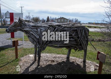 Scultura in legno di una mucca presso la fattoria la Ferme Gilles Landry su QC 132 a Rivière-Ouelle, Quebec, Canada Foto Stock