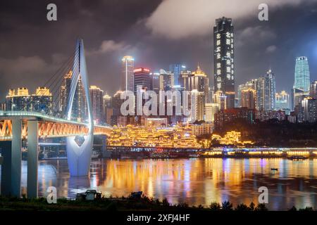 Chongqing, Cina - 29 settembre 2017: Vista notturna dei grattacieli e del Ponte Qianximen (Ponte Qiansimen) sul fiume Jialing nel centro cittadino. Foto Stock