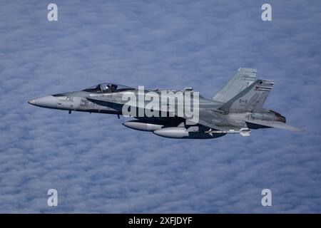 Un North American Aerospace Defense Command CF-18 Hornet vola in formazione con un C-130J Super Hercules dell'Alaska Air National Guard durante un NO di routine Foto Stock