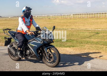 BANGKOK, TAILANDIA, 18 dicembre 2023, servizio di sicurezza aeroportuale gira intorno all'aeroporto recintato in moto Foto Stock