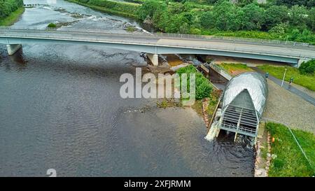 Hydro Ness il generatore idroelettrico in acciaio argentato sulle rive del fiume Ness Scozia e A8082 strada Holm Mills Bridge Foto Stock