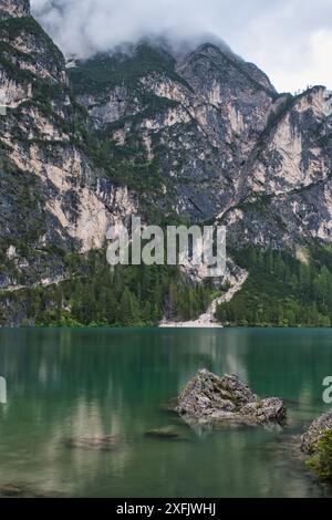 Vista panoramica delle rocce sul lago Braies in una giornata di pioggia Foto Stock
