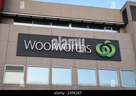 Grande cartello sopraelevato del supermercato Woolworths sul lato di un edificio, con il logo verde dell'azienda di alimentari Foto Stock