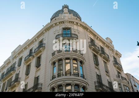 Edificio storico con tetto a cupola e balconi ornati. L'elegante design architettonico e la facciata dettagliata creano un suggestivo punto di riferimento urbano. Foto Stock