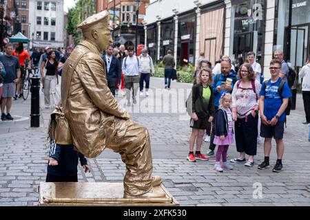 Artista di strada come statua vivente dipinta in metallo a Covent Garden che delizia la folla riunita il 30 giugno 2024 a Londra, Regno Unito. Foto Stock