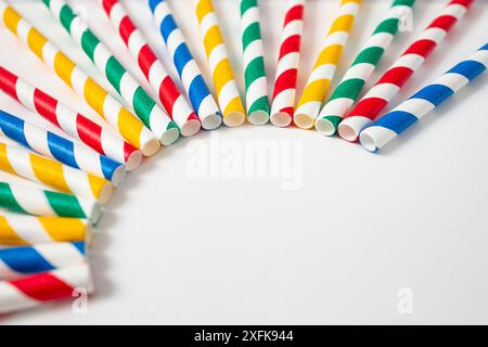 Cannucce di carta colorata disposte su sfondo bianco, messa a fuoco morbida, sfondo party Foto Stock