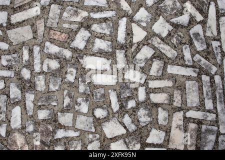 Pezzi rettangolari di marmo bianco su cemento, struttura a mosaico invecchiato Foto Stock